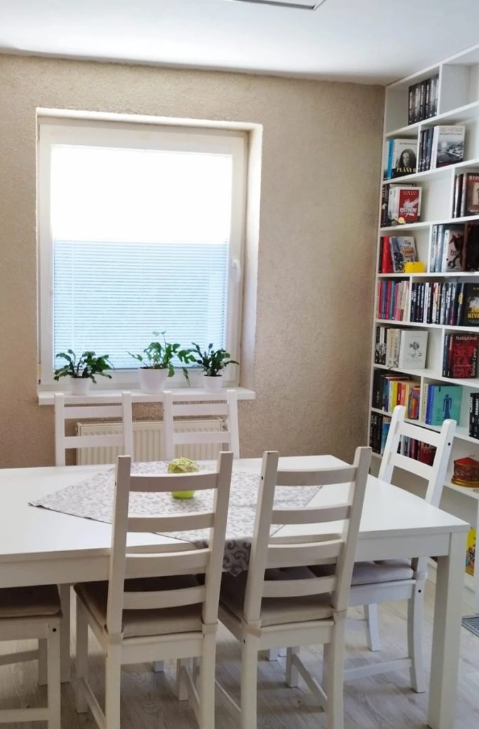 Comedor con papel pintado líquido BIOPLAST 1019 junto a una biblioteca